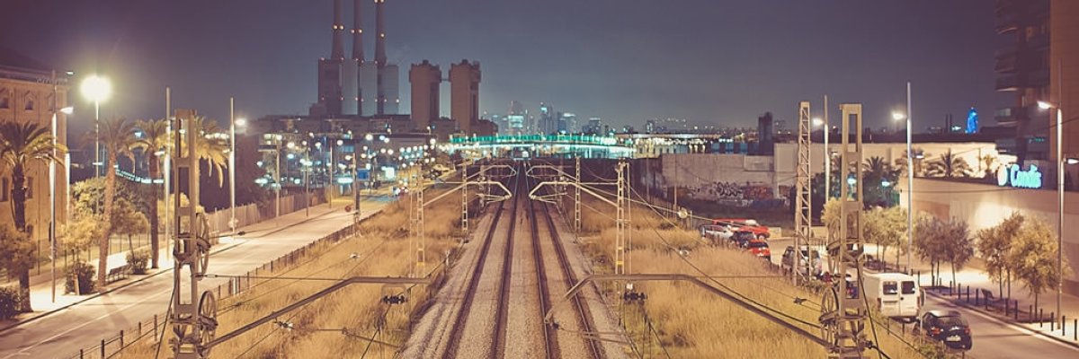 Railway tracks leading toward a city at night