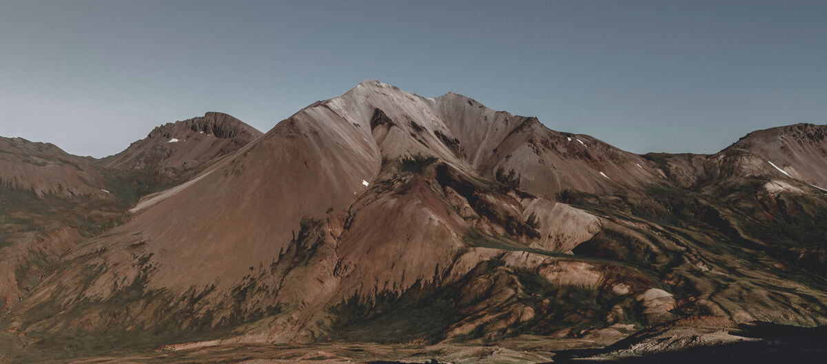 Bare, reddish-brown mountains under a clear sky